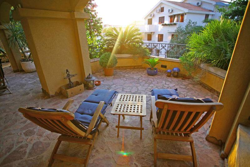 Shaded terrace with wooden loungers at Garni Hotel Meduza